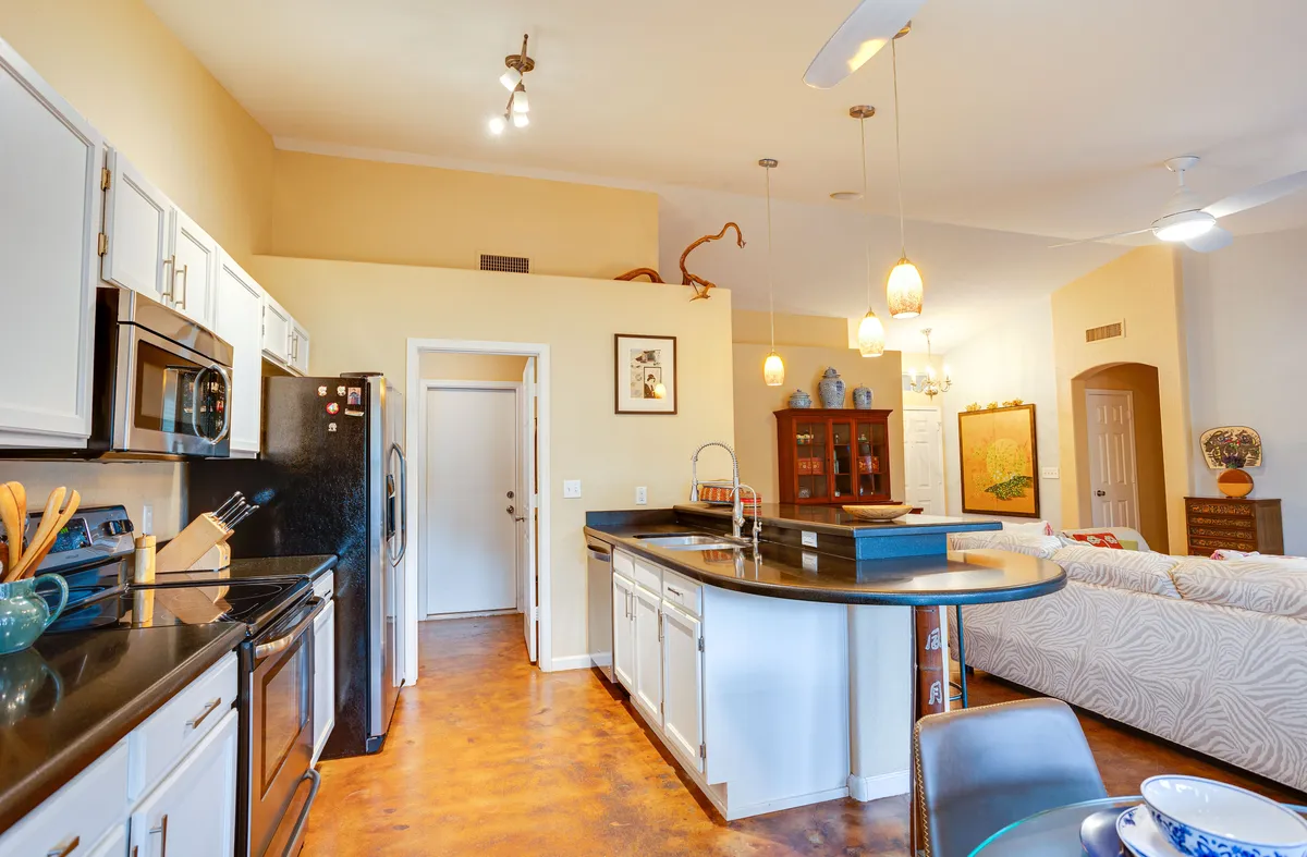 A view into the kitchen and dining area, with a kitchen island, stainless steel appliances, and a dining space designed for gatherings and daily routines. While not showing the laundry room directly, its proximity to the kitchen is implied, supporting the narrative of practical amenities close at hand.